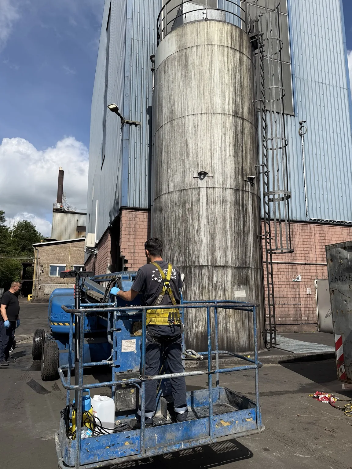 Reinigung eines Industriebehälters mit Hubarbeitsbühne
